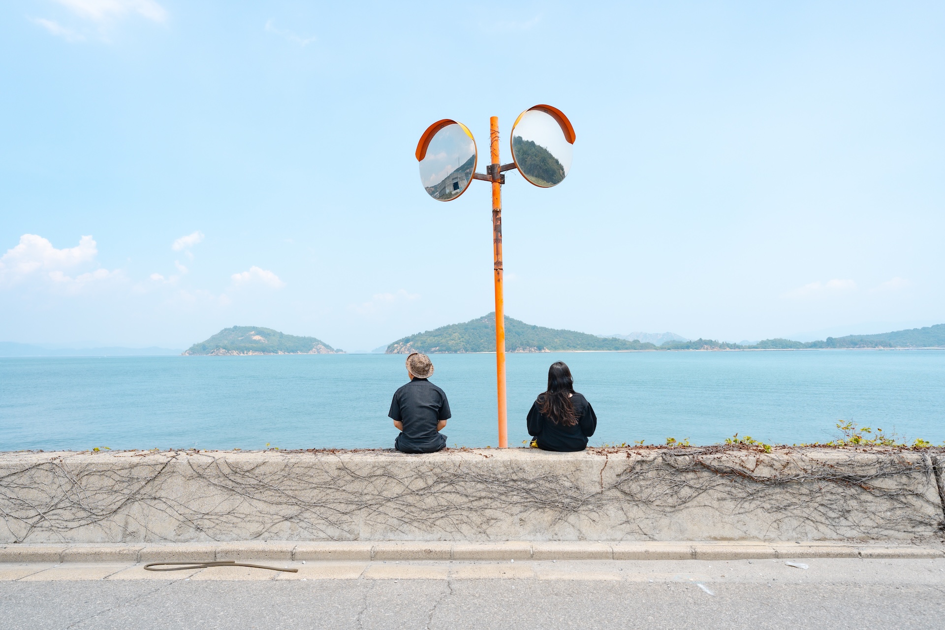 夏の海で旅行をしている写真。海辺に佇む二人